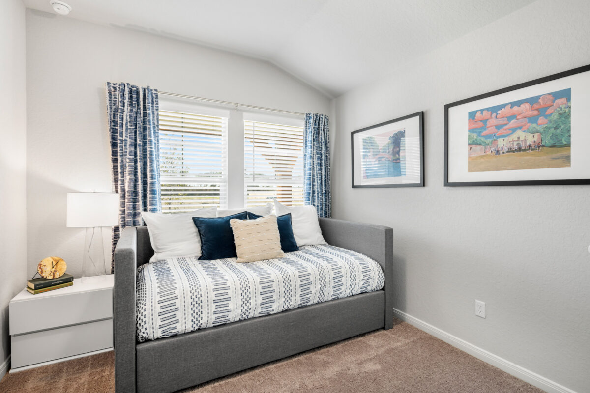 Photo of secondary bedroom furnished with twin bed and framed art.