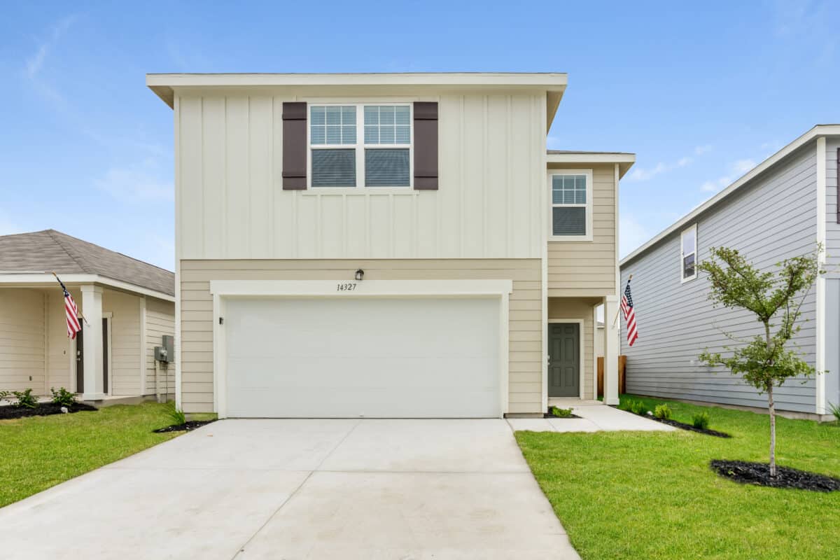 Front view of beige house with white trim