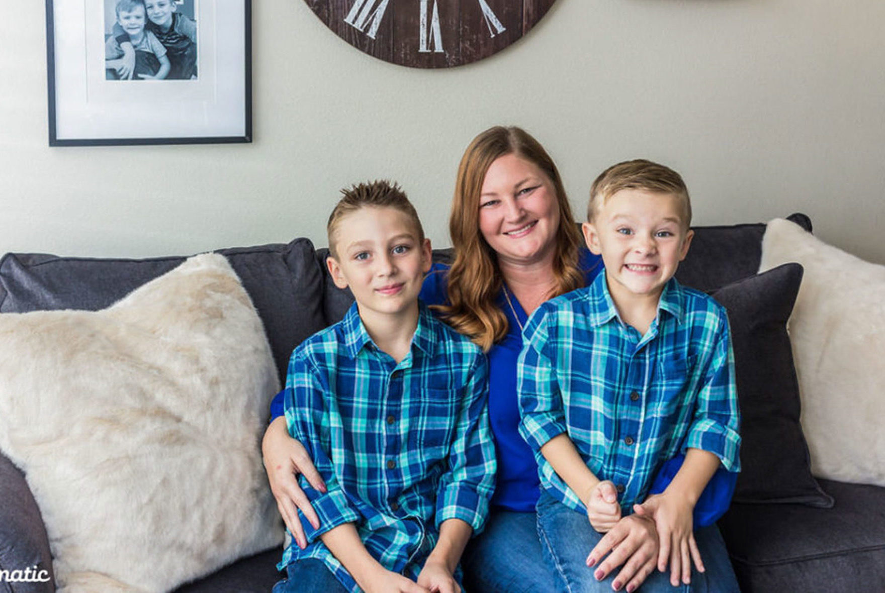 A mom and two young boys sitting on couch.