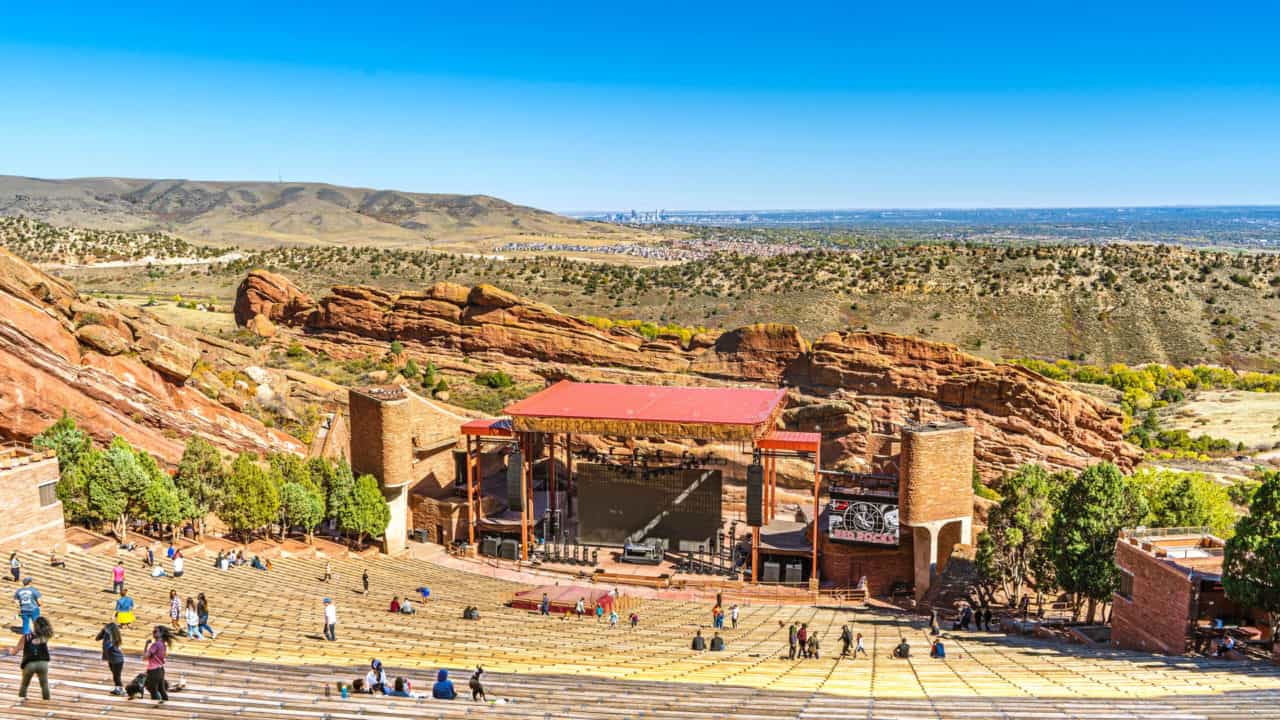 Day-time view of amphitheater seats, stage and surrounding desert area.
