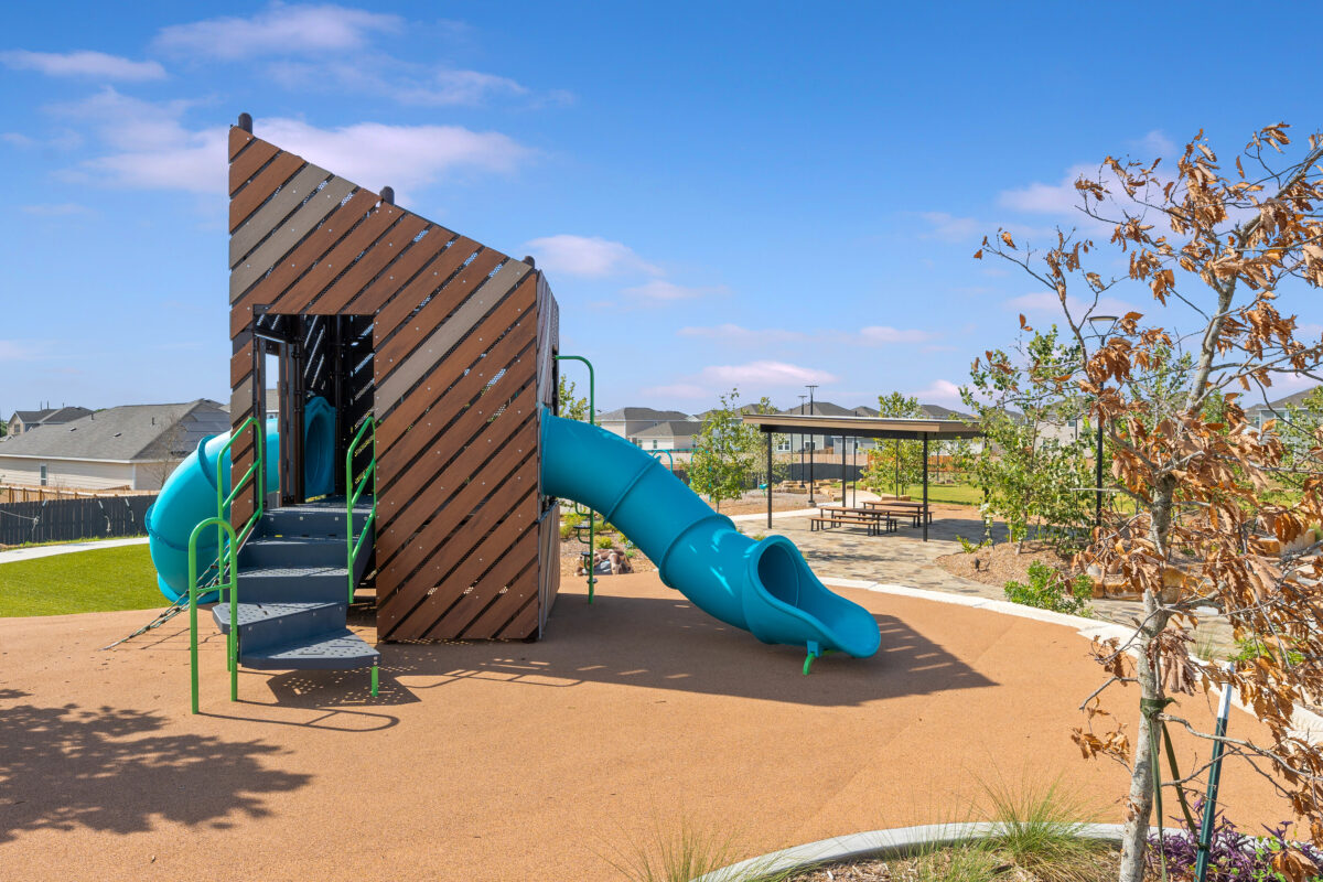 View of children's play structure and shaded seating area nearby.