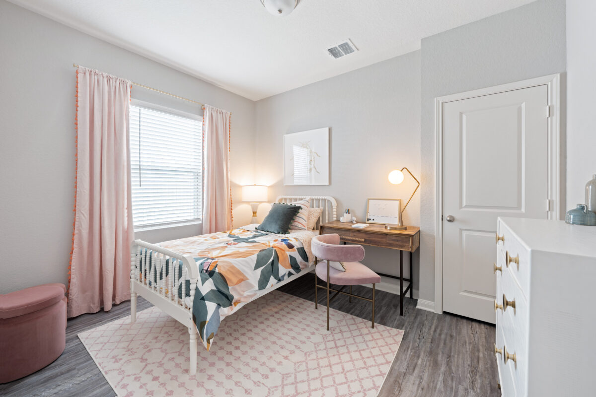 Secondary bedroom with twin bed and staged with desk and chair.