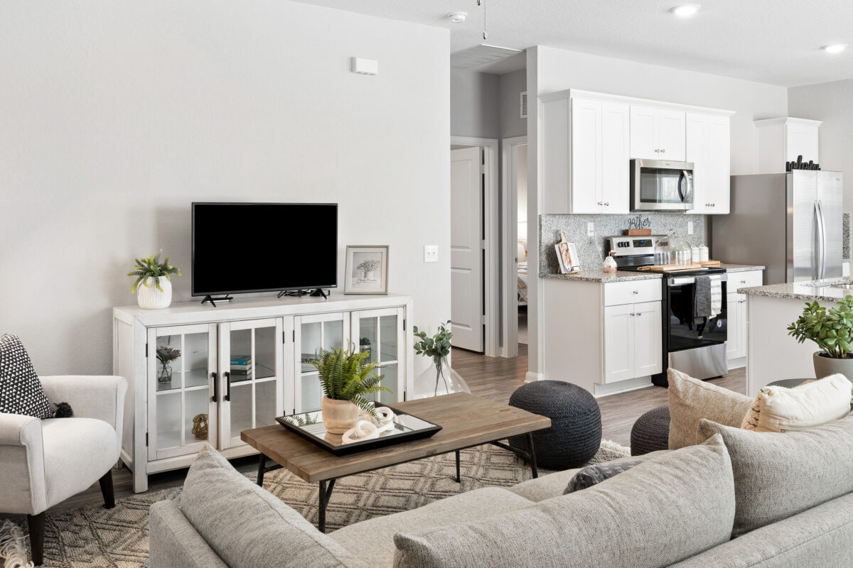 Model living room and partial kitchen view at Trails at Culebra