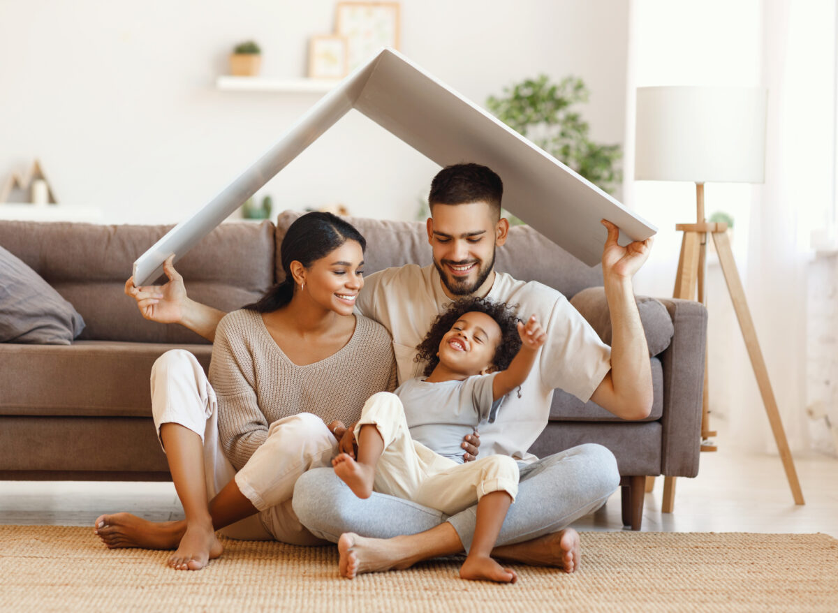 Happy multiethnic family under roof stock photo