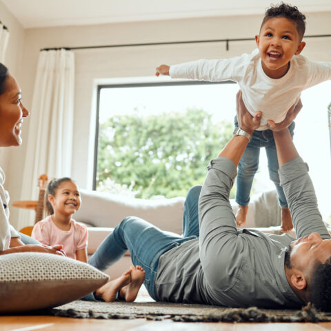 Shot of a young family playing together on the lounge floor at home