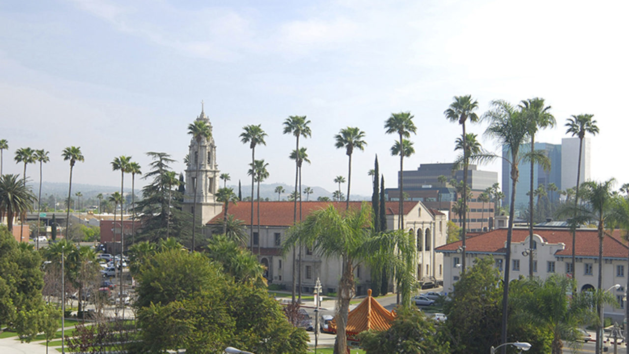 View of historical downtown city center with view of palm trees, park, and high-rise buildings in the distance